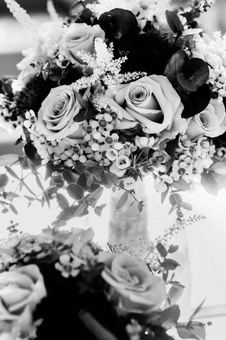 Ein Arrangement aus verschiedenen Blumen, hauptsächlich Rosen in Schwarz-Weiß.