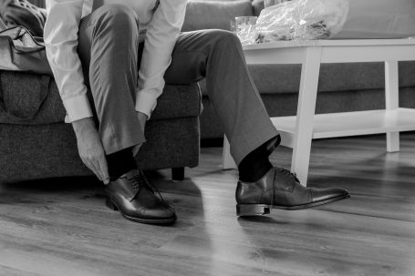 Eine Person zieht angepasste Schuhe an, während sie auf einem Sofa sitzt.